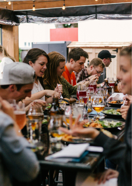 Coworkers sharing a meal at a lively dinner, perfect for team bonding or group date night fun